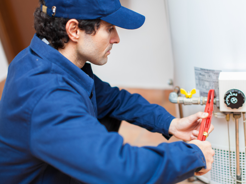 Plumber providing water heater repair service near the thermostat and gas control valve for a residential home in Chester County, PA