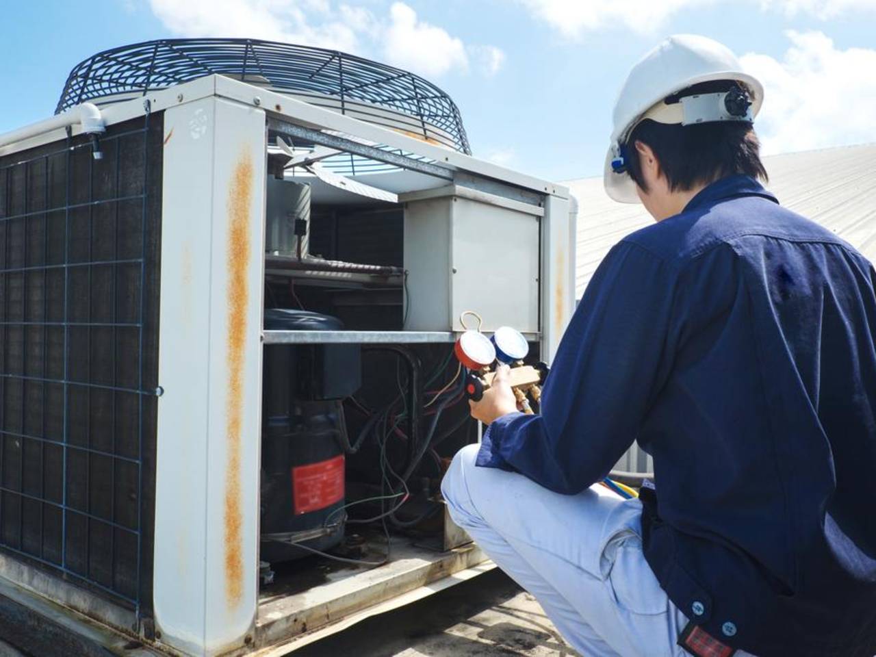 A friendly Battavio technician performing a heating repair service on a furnace in a Chester County home.